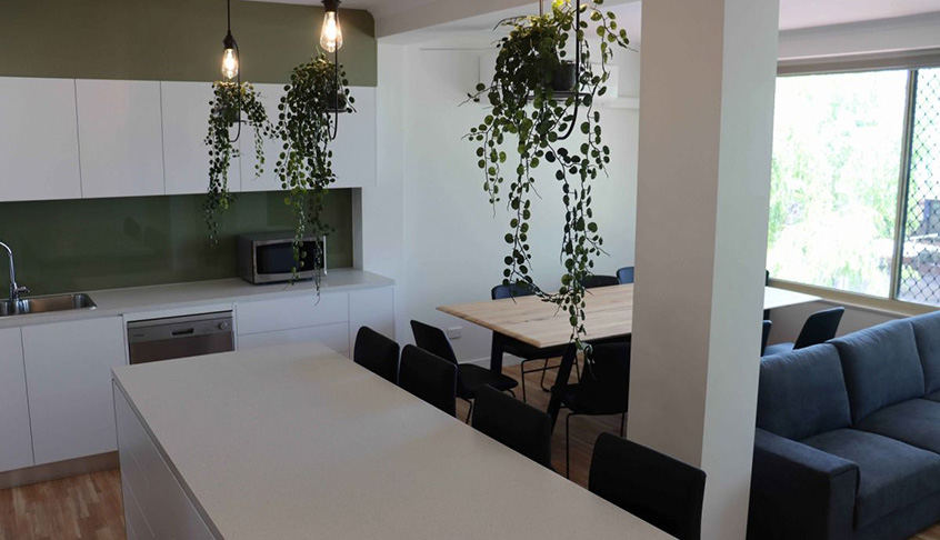 A kitchen and living room featuring a couch and a table, showcasing a cozy and inviting open-concept space.
