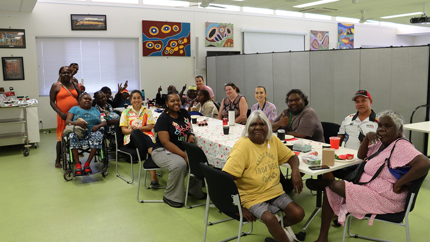 A diverse group of people engaged in conversation while sitting around a table.