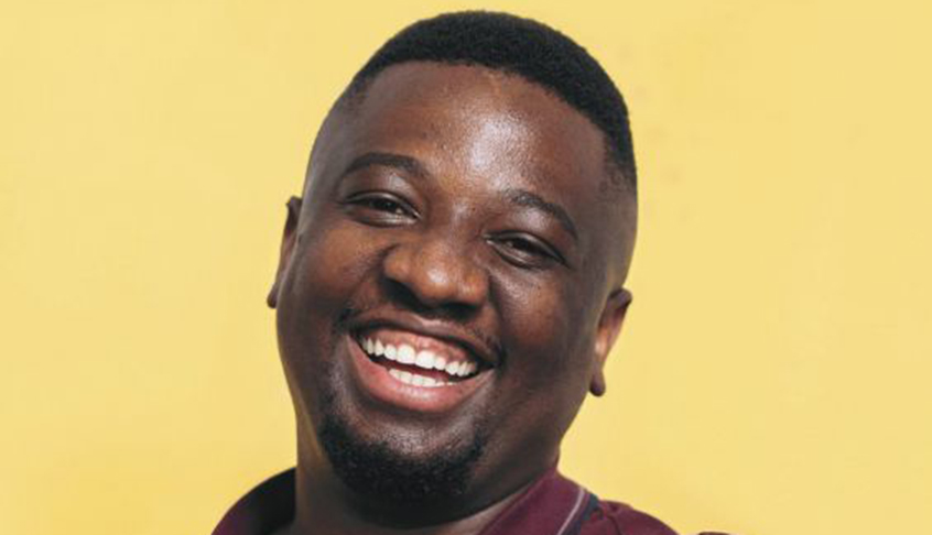 A man smiling while wearing a maroon shirt, exuding a friendly and approachable demeanor.