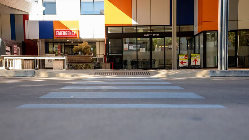 A pedestrian crosswalk marked by a clear white line on the pavement, indicating a safe crossing area.
